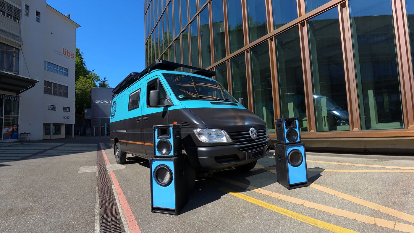 Der bass.cruiser von vorn mit zwei Boxentürmen vor einer Glasfassade